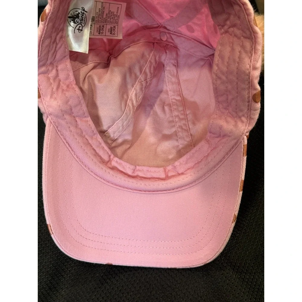Pink polka-dot cap topped with two fluffy faux fur pom poms